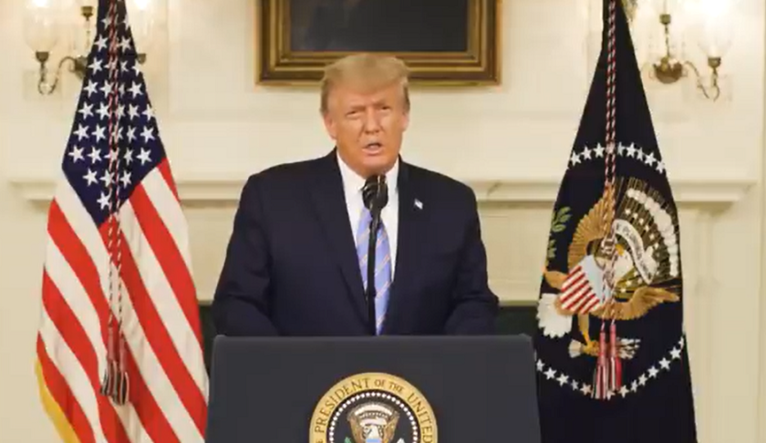 a man in a suit speaking into a microphone