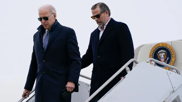 two men in suits walking up a staircase